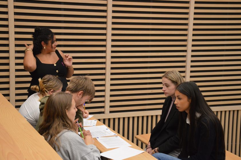 Une bénévole anime un échange avec des étudiants pendant un atelier