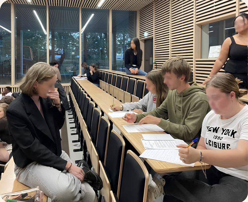 Une bénévole échange avec des étudiants pendant un atelier de sensibilisation en amphithéâtre